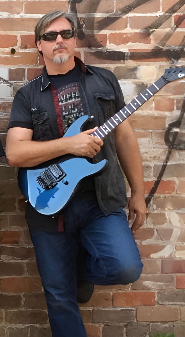 String Shock Steve with his 1986 blue Charvel electric guitar.